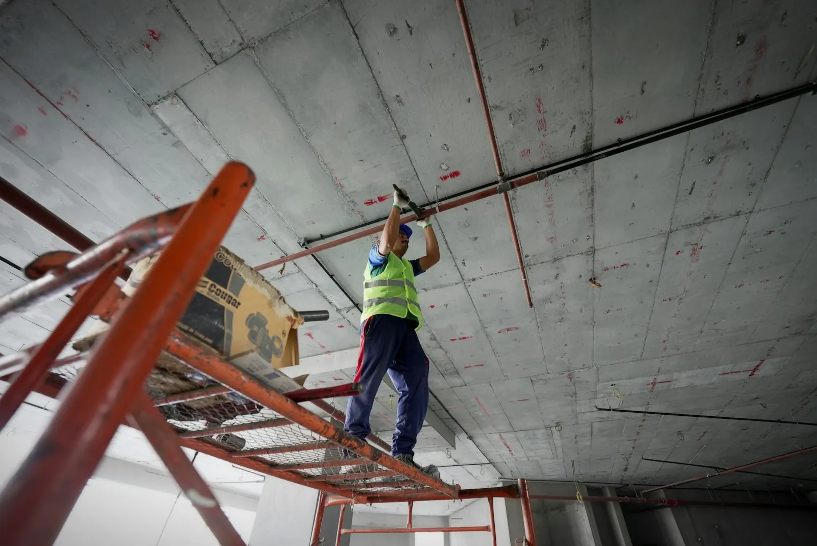 Électricien en tenue de sécurité sur un chantier de logements collectifs