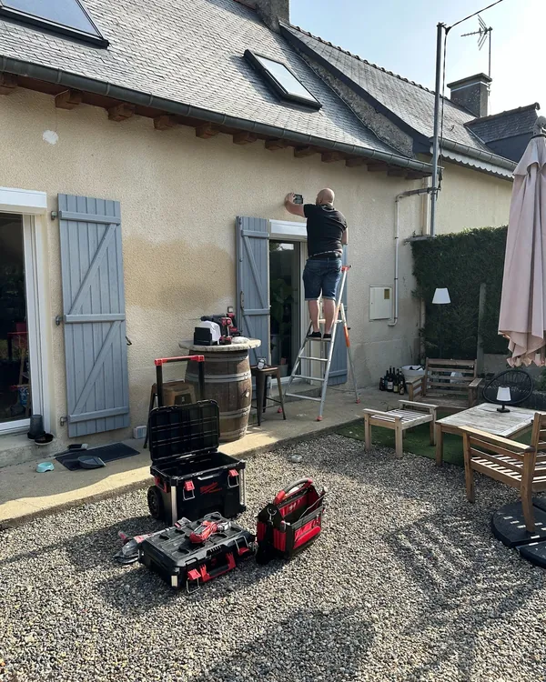 Électricien AUREA intervenant sur la façade d'une maison habitée