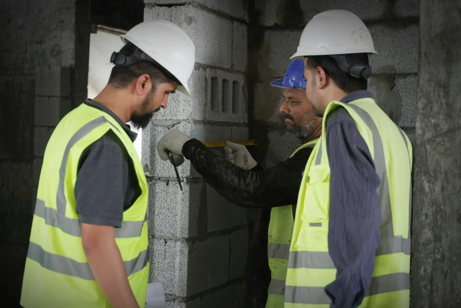 Équipe en casques et gilets haute visibilité prenant des mesures sur un chantier