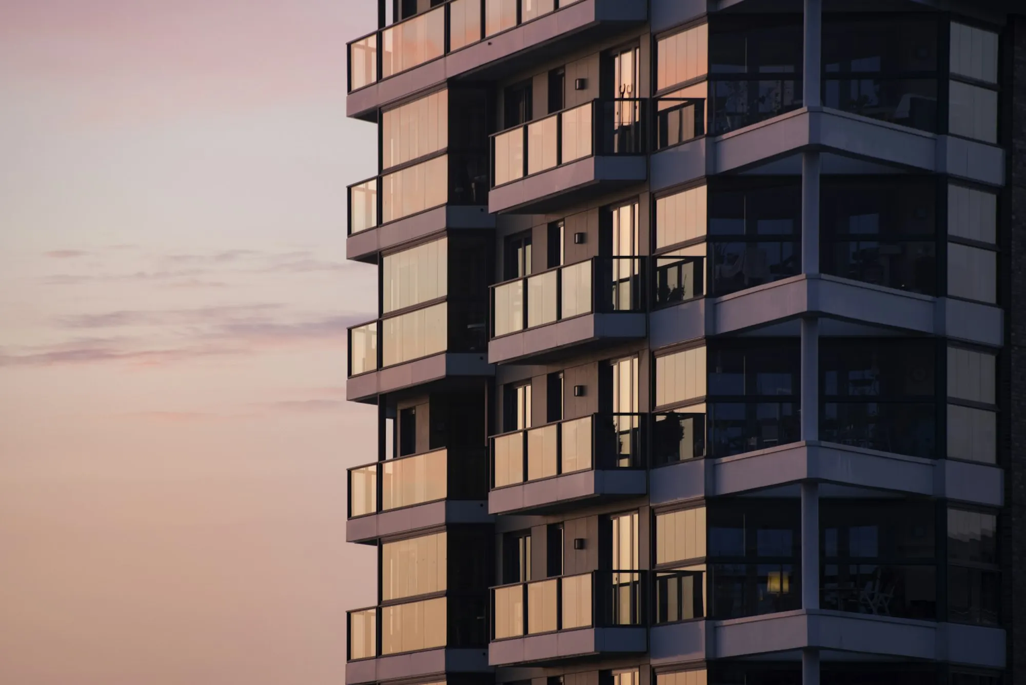 Résidence neuve contemporaine avec balcons vitrés au crépuscule